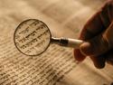 Small writing magnified through a magnifying glass