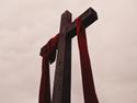 Christian cross with red ribbon hanging from it