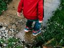A child jumping into a puddle