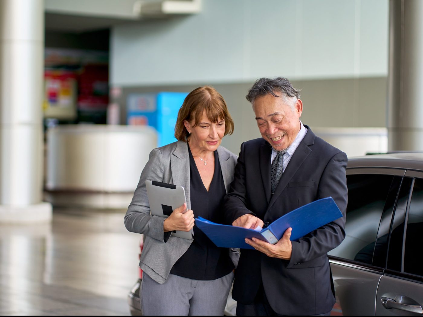 Two senior business people looking at blue paper chart for working out of office before go to meeting with customer at office meeting room.
