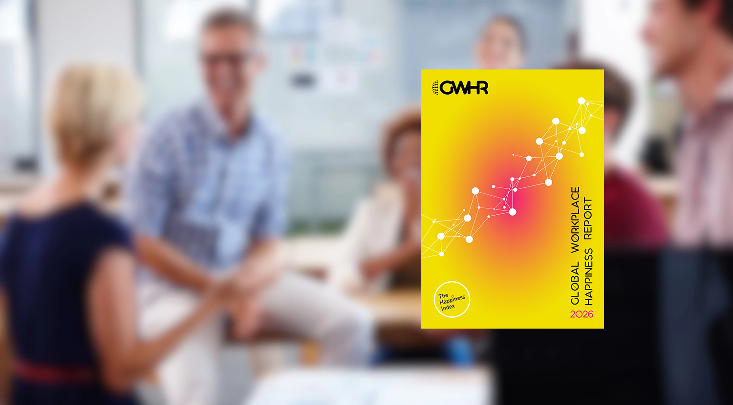 A blurred background showing a diverse group of people engaged in a positive, collaborative office meeting. Centered in the foreground is a sharp, clear image of the Global Workplace Happiness Report 2026 cover, featuring a vibrant yellow and pink gradient and a white geometric network graphic.